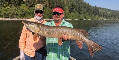 Man standing next to another man holding a large Pike