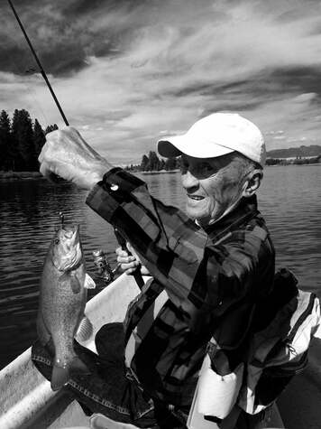 Older man catches small fish in black and white